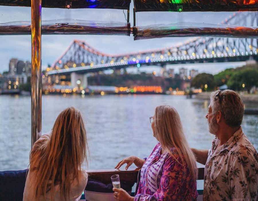 Brisbane: Sunset City Lights Cruise 5.30pm or 6pm <em>seasonal – Key points at a glance’ /></p>
<ul>
<li><strong>Sunset timing changes by season:</strong> Depart at 5:30pm from April 1 to September 30, or at 6pm from October 1 to March 31.</li>
<li><strong>Story Bridge is the visual star:</strong> The route gives you a memorable river-level view of Brisbane’s best-known bridge.</li>
<li><strong>A share board is included:</strong> You receive complimentary charcuterie-style nibbles, while drinks and extra snacks cost more.</li>
<li><strong>The mood is quiet and relaxed:</strong> Background music replaces a running tour commentary.</li>
<li><strong>South Bank is the departure point:</strong> Meet at the Cultural Centre Public Pontoon, in front of the cultural centre.</li>
<li><strong>The boat has useful basics:</strong> A licensed bar and onboard male and female toilets are available.</li>
</ul>
<h2>Brisbane at dusk, then under lights</h2>
<p><img width="900" height="675" decoding="async" src=
