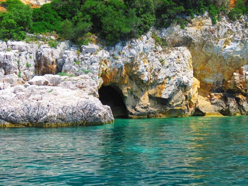 Krk: Golden Beach and Blue Cave Cruise with Welcome Drink - Swimming through the blue water of Plavnik Cave